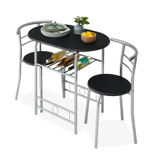 Compact dining set with a black oval table and two chairs featuring silver metal frames. Includes underneath rack storing wine bottles and tabletop decor with a plant and fruit basket. Perfect for small spaces.