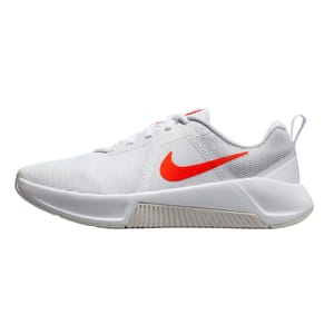 White Nike MC Trainer shoes with a mesh upper, featuring an orange Swoosh logo on the side. They have a sturdy midsole and a heel tab for easy wear.