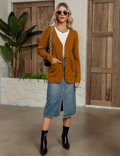 A mustard yellow button-up cardigan with two front pockets is worn over a white top, paired with a knee-length denim skirt and black ankle boots.