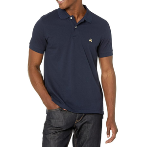 Navy blue solid piqué slim fit polo with a small embroidered logo on the chest, featuring a classic collar, short sleeves, and button placket, paired with dark denim jeans.