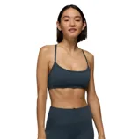 A person is wearing a dark teal sports bra with thin straps and matching high-waisted leggings, ideal for athletic activities or workouts.