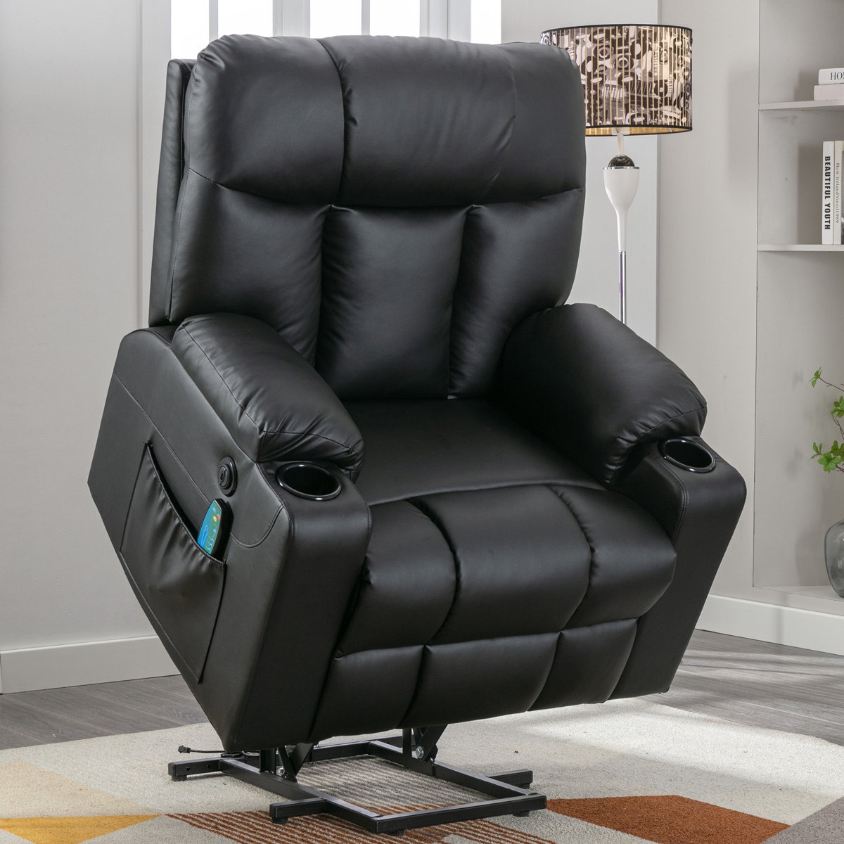 A black leather recliner chair with built-in cup holders, remote control storage, and a lift feature for easy access.