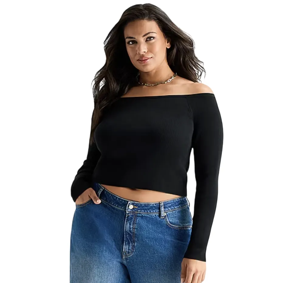 A woman is wearing a black off-shoulder long-sleeve top paired with high-waisted blue jeans.