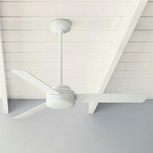 A three-blade white ceiling fan is mounted on a ceiling with white planks.