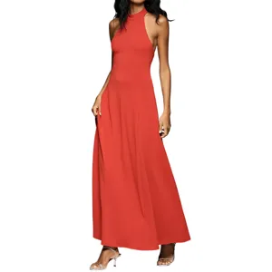 A woman wears a sleeveless, floor-length reddish-orange gown with a high neckline, paired with silver strappy heels.