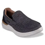A Skechers slip-on shoe in dark gray with a textured pattern, featuring a white sole and tan interior accents.
