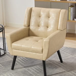A beige tufted vegan-leather armchair features an elegant design with button detailing, a high back, angled arms, and sturdy black wooden legs.