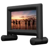 An inflatable movie screen with a black frame displays an image of people holding sparklers on a beach at sunset.