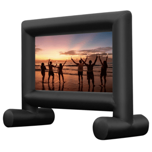 An inflatable movie screen with a black frame displays an image of people holding sparklers on a beach at sunset.
