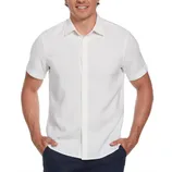 A man is wearing a short-sleeve, white button-up shirt with a collar, paired with dark trousers.