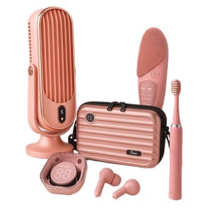 A collection of rose gold travel gadgets including a portable fan, facial cleansing brush, toothbrush, digital clock, wireless earbuds, and a small suitcase-style organizer bag.