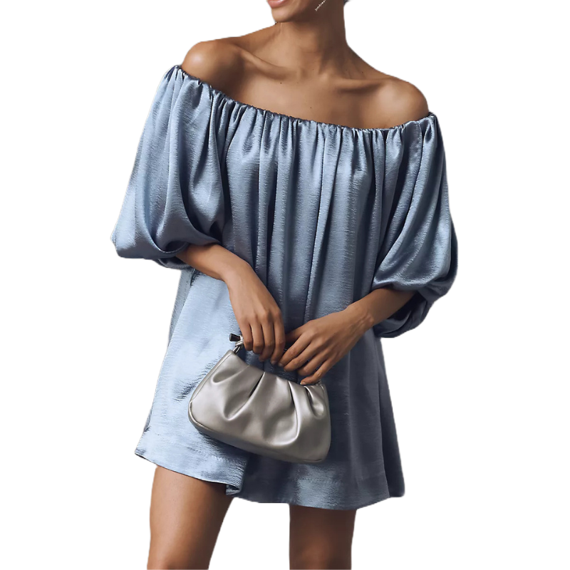 A woman in an off-the-shoulder, puff-sleeved, light blue satin dress holds a small silver handbag.