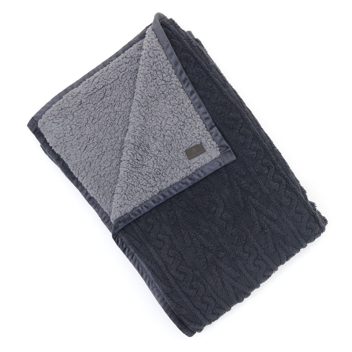 An oversized reversible throw blanket with one side in cable knit and the other in plush, sherpa-style fleece, both in shades of grey.