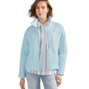 Light blue quilted jacket over a striped button-up shirt and light blue jeans.