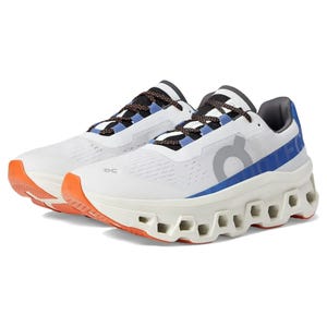 A pair of white running shoes with blue and orange accents and a chunky sole design.