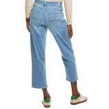 A person is wearing light blue cropped jeans with back pocket stitching, a beige ribbed sweater, and beige sneakers with green accents.