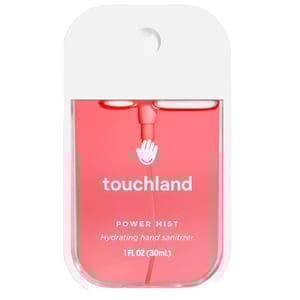 A Touchland Power Mist is a hydrating hand sanitizer in a slim, rectangular spray bottle with a pink liquid and white cap.