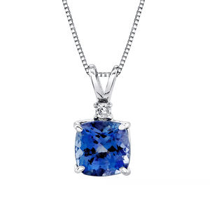 A silver necklace with a cushion-cut blue gemstone pendant and a small round diamond accent on a box chain.