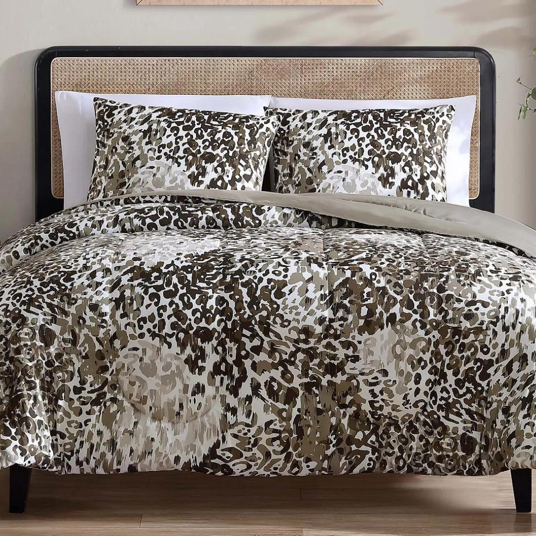 A bed with leopard print bedding set including a comforter and pillows.