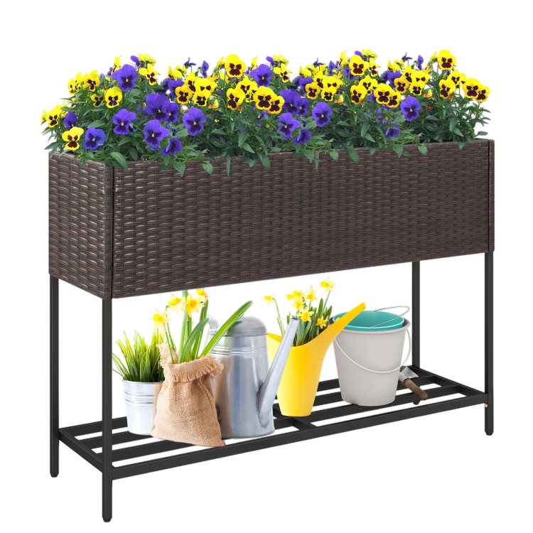 Rattan-style raised planter with purple and yellow flowers, featuring metal legs and a lower shelf. Includes gardening tools and supplies like a watering can and buckets on the shelf.