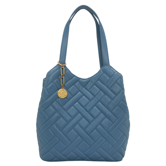 Blue quilted handbag with dual shoulder straps and a gold medallion charm attached.