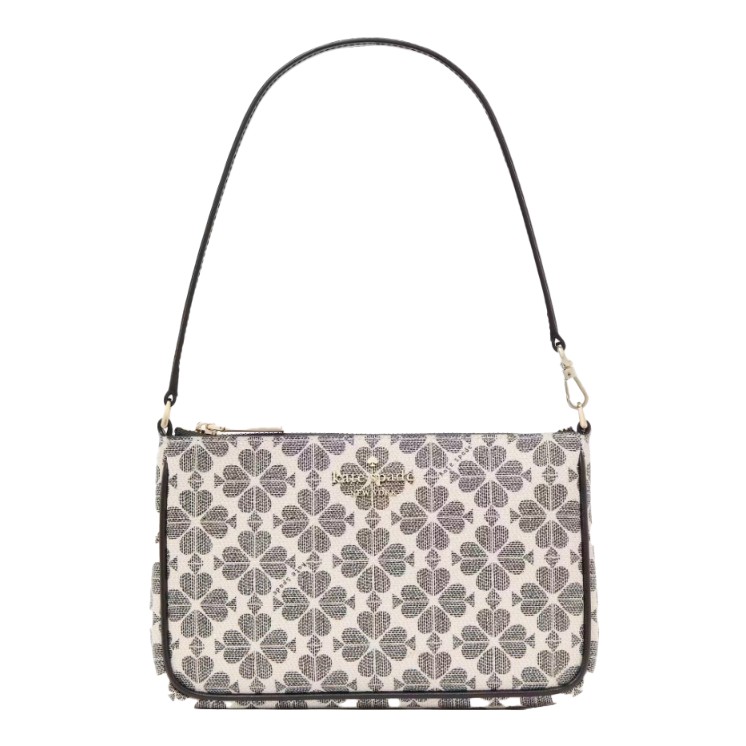 A handbag featuring a clover pattern on a light background with a detachable black shoulder strap and a gold-tone logo on the front.