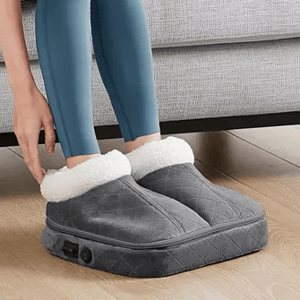 A pair of oversized, quilted gray slippers with plush white lining, featuring a side control button, designed to warm feet.
