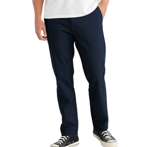 A person wearing navy blue pants with a white shirt and black sneakers.