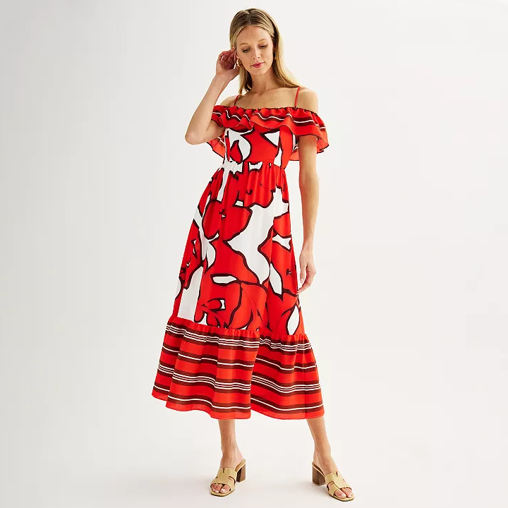 A woman in an off-shoulder red and white patterned midi dress with ruffle details, paired with beige sandals.