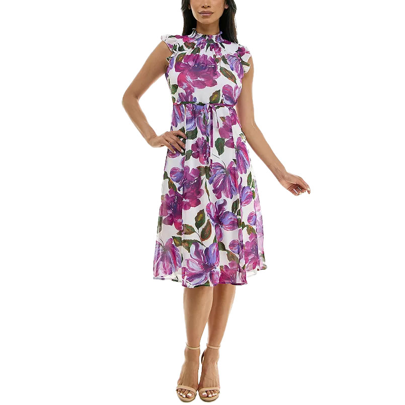 A floral midi dress featuring vibrant purple and pink flowers, with flutter sleeves and a cinched waist. It has a high neckline and a flowy A-line silhouette, paired with open-toe sandals.