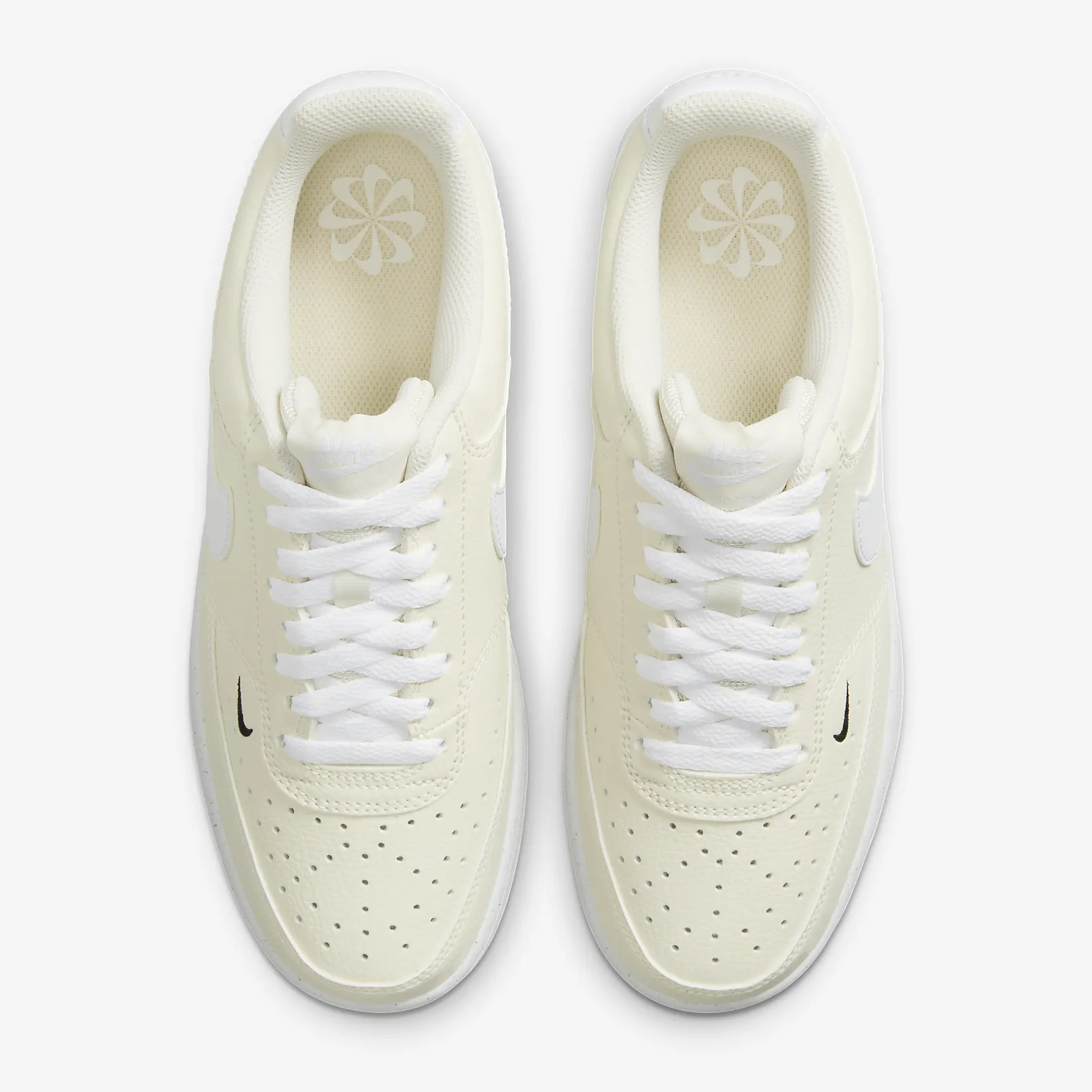 A pair of white low-top sneakers with a small dark logo on the side.