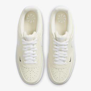A pair of white low-top sneakers with a small dark logo on the side.