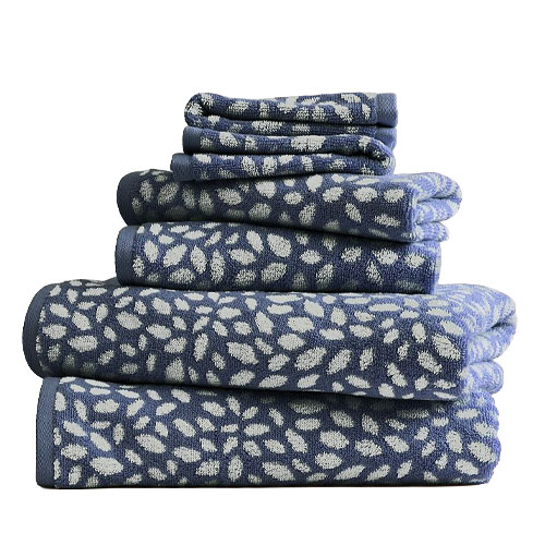 A stack of blue and white towels with a leaf pattern in various sizes.