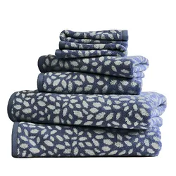 A stack of blue and white towels with a leaf pattern in various sizes.