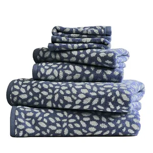 A stack of blue and white towels with a leaf pattern in various sizes.