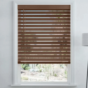 Brown horizontal window blinds partially open, with a view of a garden outside. White window frame and nearby light fixture visible.