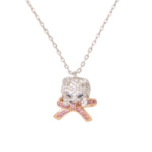 A silver chain necklace features a sparkling pendant of a cat face adorned with clear gemstones and blue eyes, accented by a pink gemstone bow underneath.