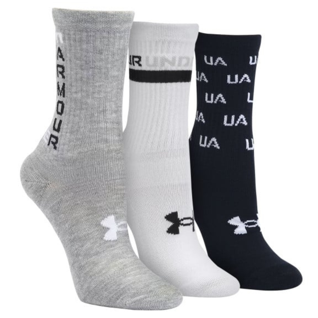 Three pairs of Under Armour cushioned crew socks are shown: one gray with \“ARMOUR\“ text, one white with a black band and logo, and one black with \“UA\“ text pattern.