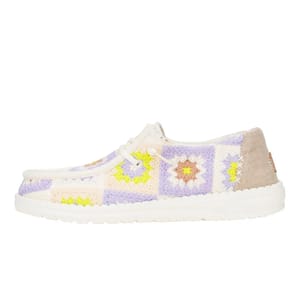 Casual shoe featuring a crochet-style multicolored patchwork pattern with floral motifs, a white sole, and beige accents on the heel.
