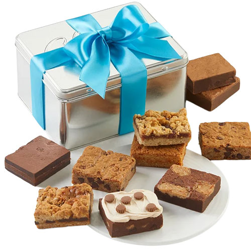 A silver tin with a blue ribbon holds a variety of brownies and dessert bars, including chocolate brownies, cookie-topped bars, and a peanut butter cup-topped piece.