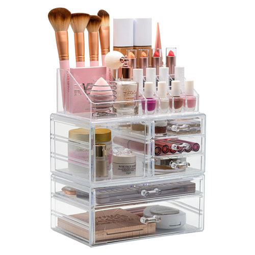A clear acrylic makeup organizer featuring three stackable drawers, holders for brushes, and compartments for lipsticks, nail polishes, and other cosmetics, offering easy access and storage for a variety of beauty products.