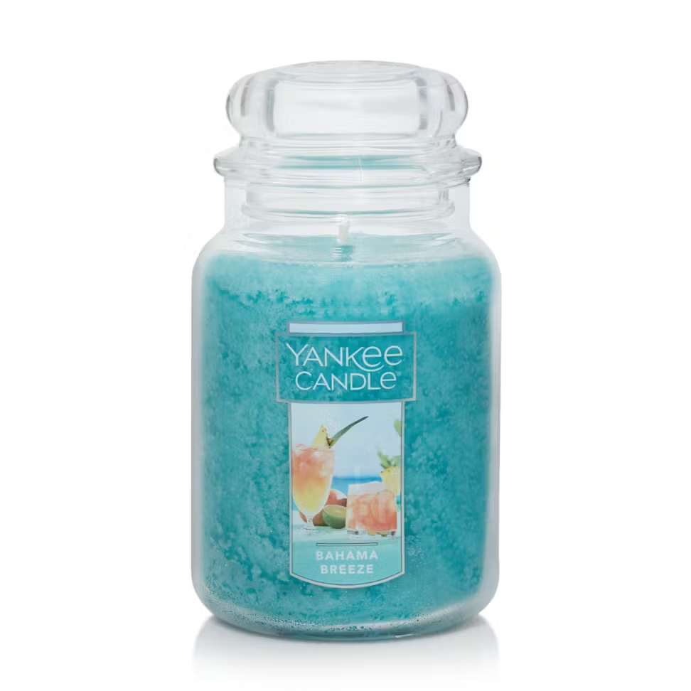 Yankee Candle in \“Bahama Breeze\“ scent, featuring a blue wax in a classic glass jar with a label depicting tropical drinks.