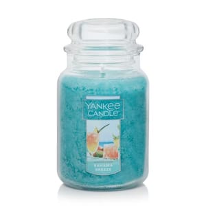Yankee Candle in \“Bahama Breeze\“ scent, featuring a blue wax in a classic glass jar with a label depicting tropical drinks.