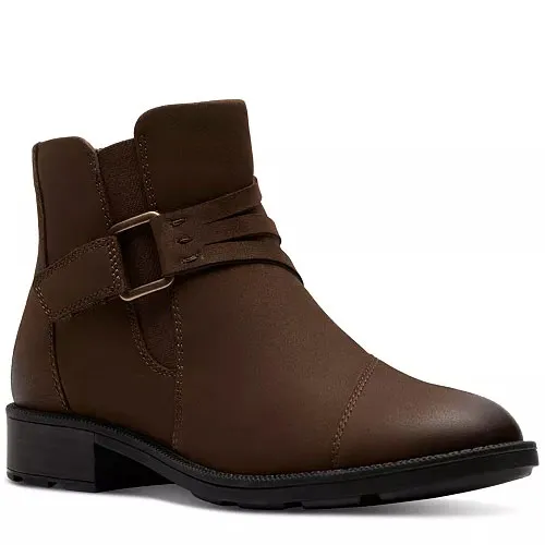 Brown ankle boot with a low heel and decorative straps featuring buckle accents.