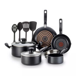 A set of black cookware including two pots with lids, a saucepan, two frying pans with patterned interiors, and four cooking utensils.