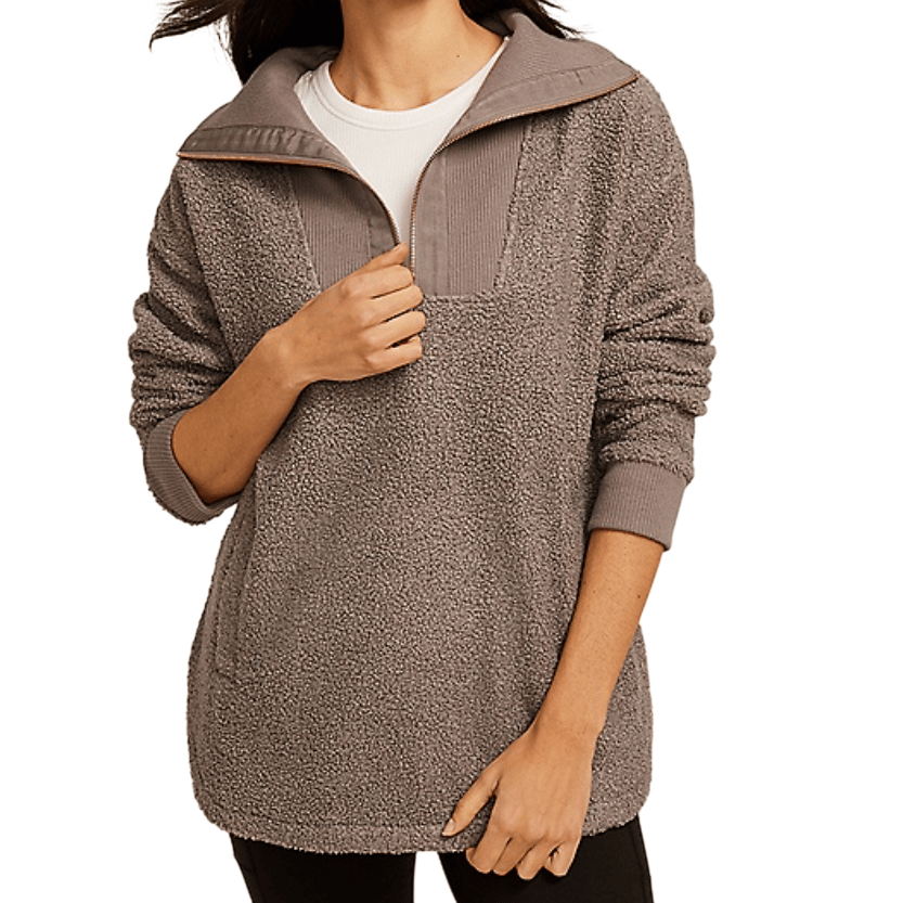 A person is wearing a cozy, textured gray pullover with long sleeves and a quarter-zip design, layered over a white shirt.