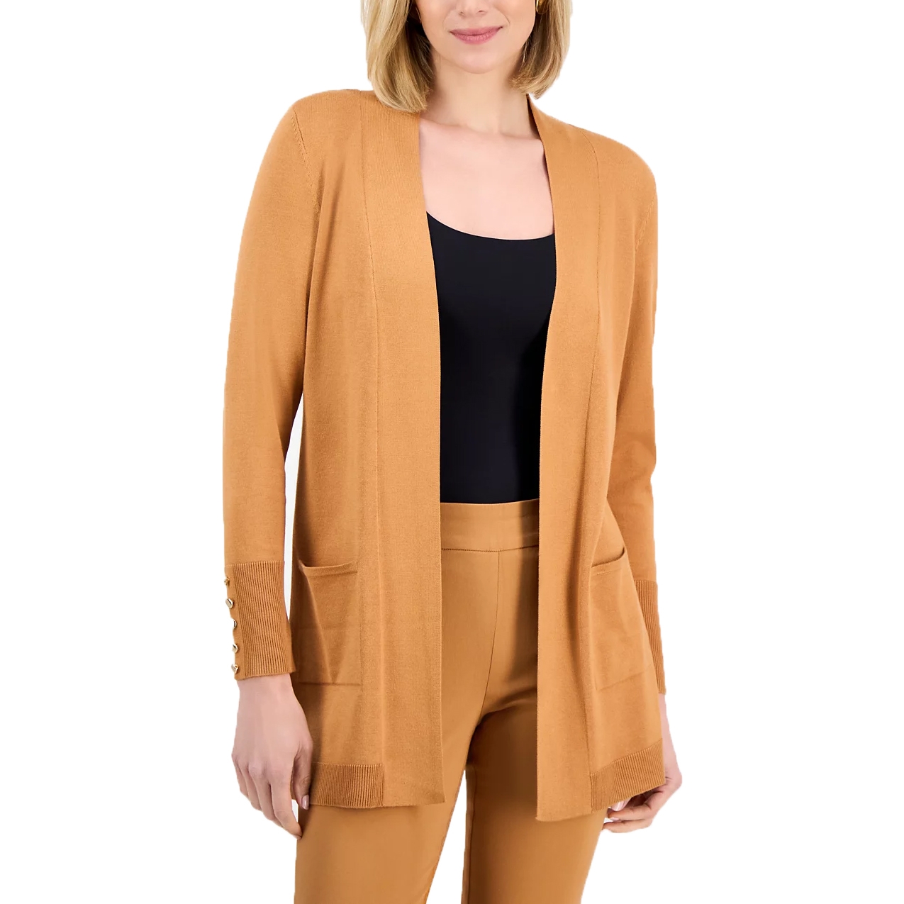 A woman is wearing a camel-colored open-front cardigan with pocket details and gold button accents on the sleeves, paired with matching high-waisted pants and a black top.