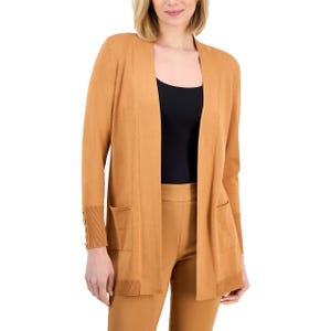 A woman is wearing a camel-colored open-front cardigan with pocket details and gold button accents on the sleeves, paired with matching high-waisted pants and a black top.