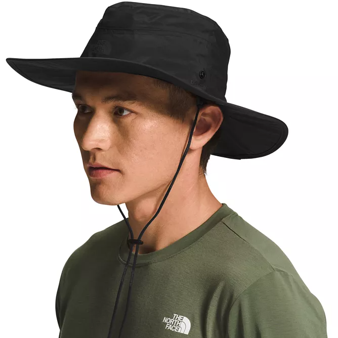 The North Face Brimmer Hat is a black, wide-brimmed hat with an adjustable chin strap, designed for sun protection. It features the brand's logo and is made for outdoor activities.