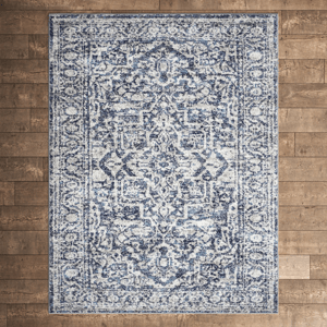 A rectangular area rug with a blue and white intricate floral and geometric pattern on a wooden floor.